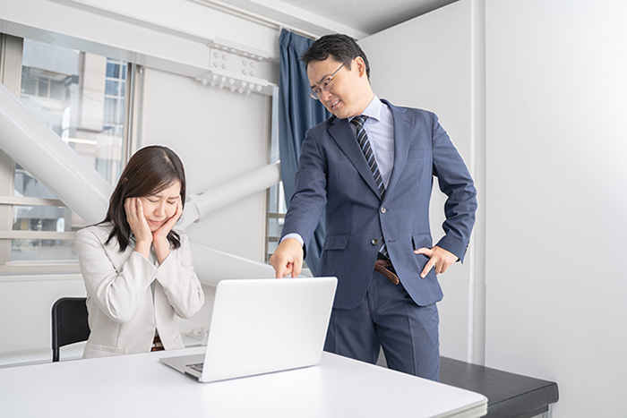 細かく叱責しながら指示を出す上司と悩む部下
